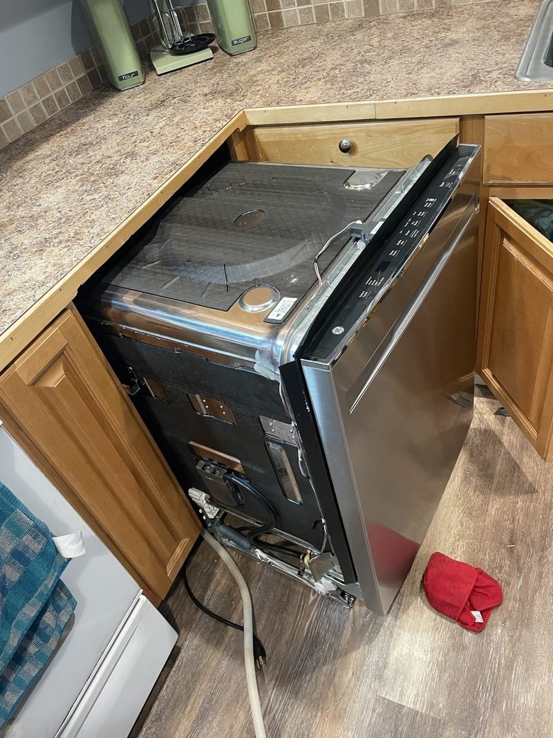 Dishwasher pulled out from the cabinet for repair
